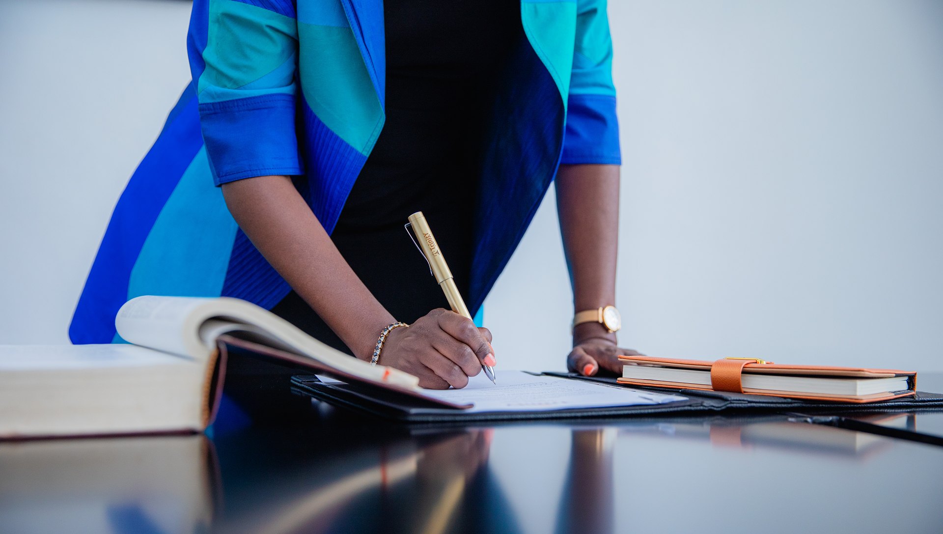 A Trinity Lawyers partner signing a document at her desk